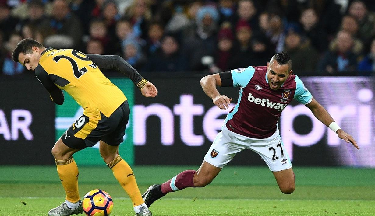 Gelandang Arsenal, Granit Xhaka (kiri), berebut bola dengan pemain West Ham United, Dimitri Payet, dalam lanjutan Premier League di Olympic Stadium, London, Sabtu (3/12/2016). (AFP/Justin Tallis)