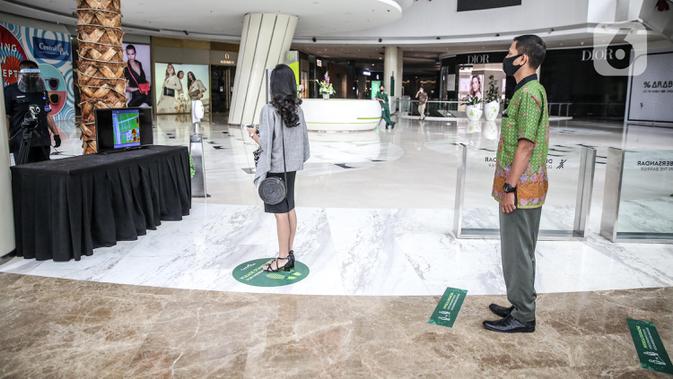 Karyawan antre mencoba alat pendeteksi suhu tubuh di Mal Central Park, Jakarta, Rabu (3/6/2020). Selain menerapkan protokol kesehatan ketat, pusat perbelanjaan juga menyediakan fasilitas pendukung 'physical distancing' sebagai persiapan operasional di era normal baru. (Liputan6.com/Faizal Fanani)