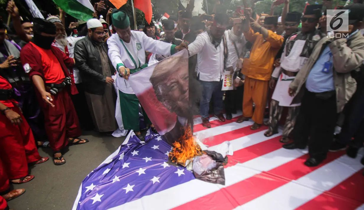 Pengunjuk rasa membakar bendera Amerika Serikat dan foto Donald Trump saat berunjuk rasa di depan Kedubes AS, Jakarta, Senin (11/12). Mereka menolak klaim sepihak Presiden Donald Trump soal Yerusalem sebagai Ibu Kota Israel. (Liputan6.com/Faizal Fanani)