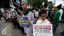 Sejumlah massa dari ormas Islam se- DIY membawa poster saat tabligh akbar di Titik Nol km, Yogya, Minggu (9/10). Mereka mendukung PP Muhammadiah yang telah melaporkan Ahok ke Polda Metro Jaya atas penistaan agama. (Liputan6.com/ Boy Harjanto)