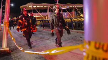 Petugas membawa jenazah korban jatuhnya helikopter di East River di New York City, AS (11/3). Akibat insiden ini, satu korban selamat dan dua korban tewas. (Eduardo Munoz Alvarez/Getty Images North America/AFP)