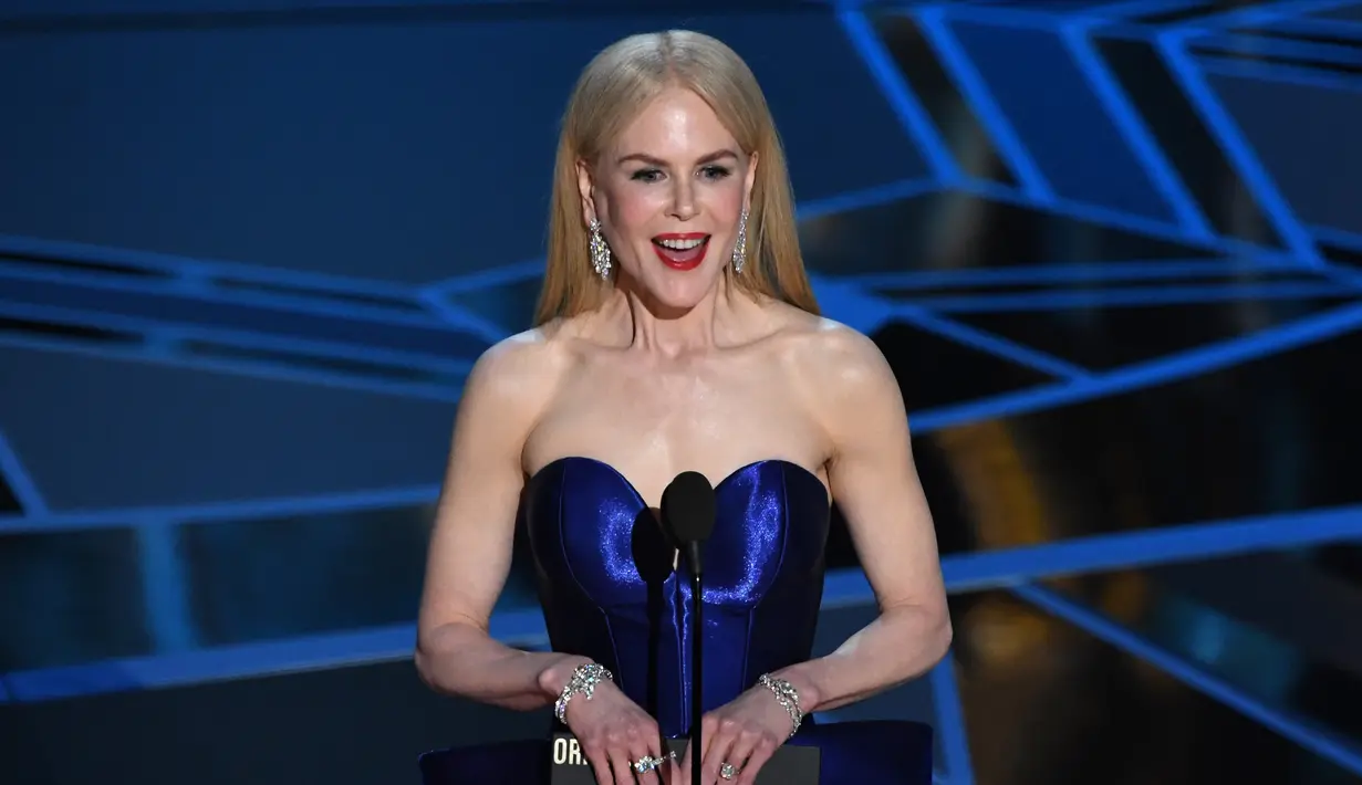 Aktris Nicole Kidman membacakan nominator untuk kategori Best Original Screenplay dalam Piala Oscar 2018 di California, Amerika Serikat, Minggu (4/3). Artis yang telah menginjak usia 50 tahun itu tampil cantik dengan balutan gaun biru. (Mark Ralston/AFP)