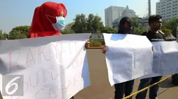 Mahasiswa Riau Jabodetabek membentangkan poster tuntutan saat unjuk rasa di depan Istana Merdeka, Jakarta, Jumat (18/9/2015). Dalam aksinya mereka mendesak pemerintah mencabut izin perusahan yang terlibat  dalam pembakaran. (Liputan6.com/Faizal Fanani)