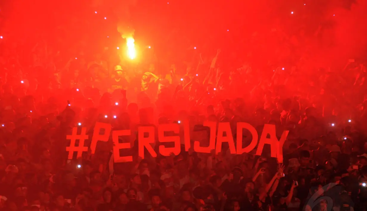 Suporter Persija menyalakan kembang api saat menyaksikan laga Trofeo Persija di Stadion GBK Jakarta, (11/1/2015). (Liputan6.com/Helmi Fithriansyah)