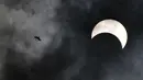 Seekor burung terbang saat gerhana matahari cincin di Bangkok, Thailand, Kamis (26/12/2019). Gerhana matahari cincin ini dapat diamati dari sejumlah wilayah mulai dari Afrika timur, seluruh Asia, Samudera India, dan Australia utara. (Lillian SUWANRUMPHA/AFP)