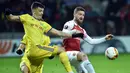 Duel antara Skhordan Mustafi dan Stanislav Dragun pada leg 1,32 besar Liga Europa yang berlangsung di stadion Borisov Arena, Borisov, Jumat (15/2). Arsenal tumbang 0-1 kontra Bate Borisov. (AFP/Sergei Gapon)