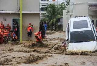 Tim penyelamat memegang tali dalam upaya mengevakuasi kendaraan dan warga yang terjebak banjir di Padang, Provinsi Sumatera Barat pada Kamis 27 November 2025. Badan Penanggulangan Bencana Daerah (BPBD) Kota Padang, Sumatra Barat melaporkan, total 27.433 warga terdampak banjir akibat hujan deras yang mengguyur wilayah tersebut sejak awal pekan lalu. (REZAN SOLEH/AFP)
