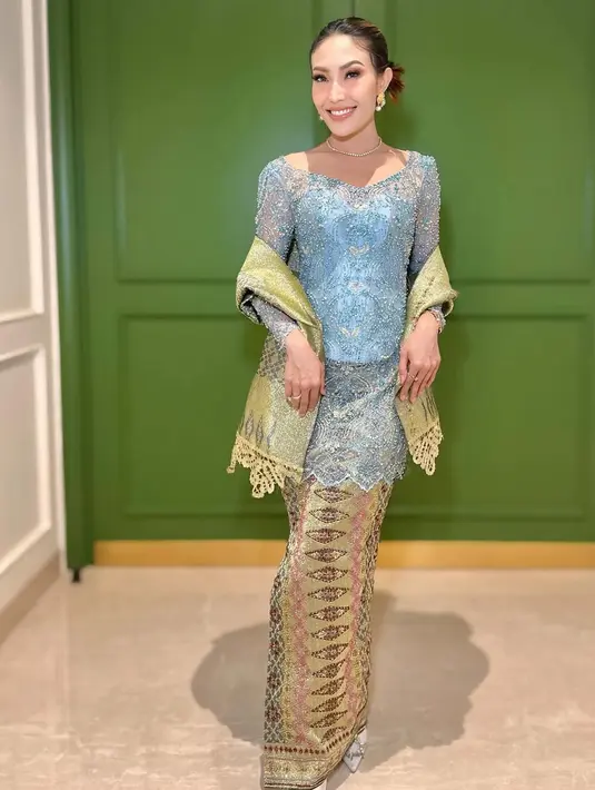 Ayu Dewi mengenakan kebaya baby blue yang dihiasi beads. Kebaya kerah square ini dipadukan selendang dan bawahan kain songket warna colorfull. [@mrsayudewi]
