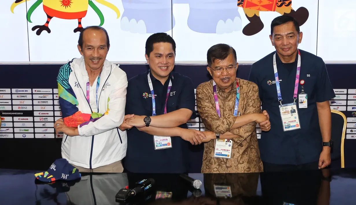 Ketua INASGOC, Erick Thohir (kedua kiri), dan Wakil Presiden, Jusuf Kalla (kedua kanan) bergandengan tangan usai meninjau Main Press Center (MPC) atau Media Center Asian Games di JCC, Jakarta, Selasa (14/8). (Liputan6.com/Fery Pradolo)
