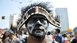 Masyarakat Papua mantan karyawan PT Freeport Indonesia melakukan penggalangan dana saat Car Free Day, Jakarta, Minggu (5/8). Dalam aksinya, mereka menjual pigura yang hasilnya digunakan untuk bertahan hidup di Jakarta. (Merdeka.com/Iqbal S. Nugroho)