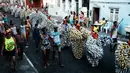 Selain menggunakan kostum kaleng, peserta karnaval menggunakan topeng oranye untuk parade Bloco Da Latinha di Madre de Deus, Brasil (9/2/2016). Setiap kostum kaleng yang dipakai Bloco Da Latinha memiliki berat sekitar 11-15 kg. (AFP Photo/Yasuyoshi Chiba)