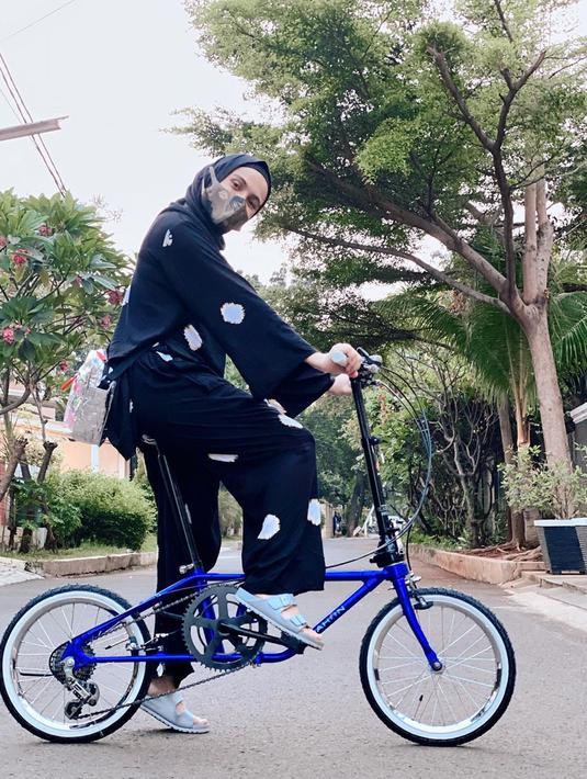 Tampil simple, wanita kelahiran 3 November 1984 ini bersepeda dengan baju setelah berwarna biru dongker dan hijab warna senada. Nycta Gina juga tampil santai dengan sandal biru muda yang manis sambil menikmati olahraga keliling komplek dengan sepeda. (Liputan6.com/IG/@missnyctagina)