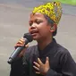 Farel Prayoga bernyanyi di hadapan Presiden Jokowi beserta para menteri dengan mengenakan beskap berwarna hitam dan celana panjang. (Tangkapan layar YouTube Sekretariat Presiden)