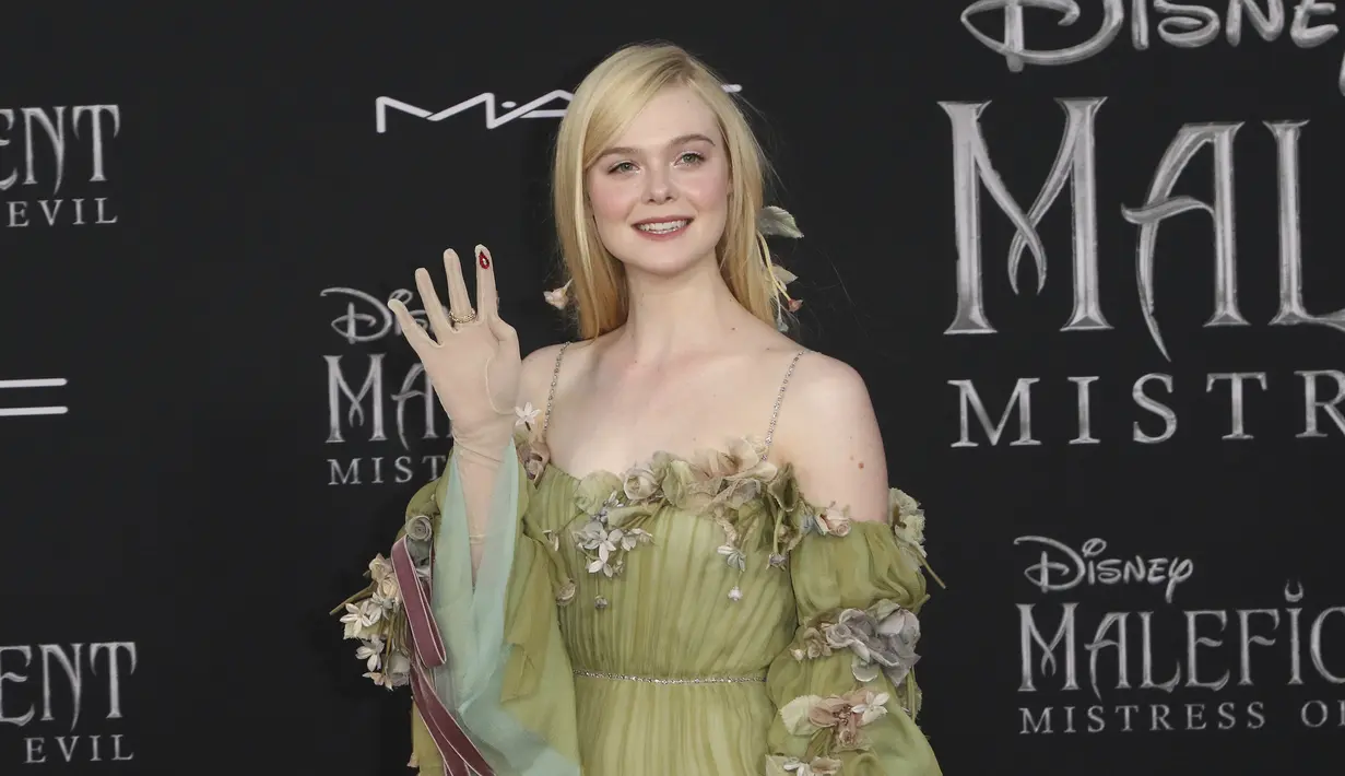 Elle Fanning tersenyum saat menghadiri pemutaran perdana film Disney "Maleficent: Mistress of Evil" di Teater El Capitan di Hollywood (30/9/2019). Elle Fanning tampil bergaun hijau dengan sarung tangan tipis dann tetesan darah merah berhiaskan permata di tangan kanannya. (AP Photo/Willy Sanjuan)