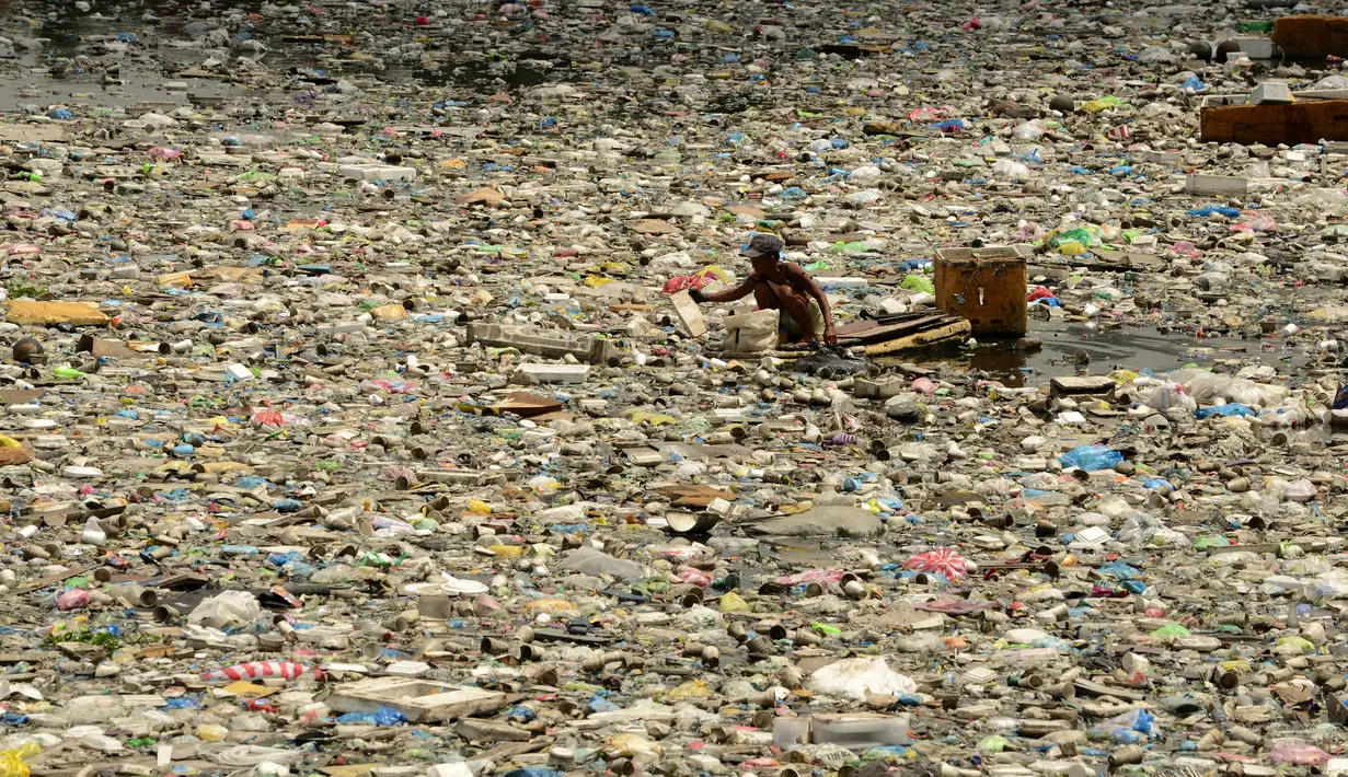 Teresita Gapayao (51) mengais sampah menggunakan rakit yang terbuat dari stereofoam di aliran Sungai Estero de Vitas di Tondo, Manila, Filipina, Kamis (21/4). Teresita mengumpulkan botol plastik atau apapun yang bisa dijual ke junkshops. (Noel CELIS/AFP)