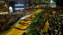 Demonstran membentangkan spanduk dalam warna bendera Brasil yang bertuliskan dalam bahasa Portugis "Cuci Mobil" saat menggelar aksi protes di Rio de Janeiro, Brasil (3/4). (AP / Silvia Izquierdo)