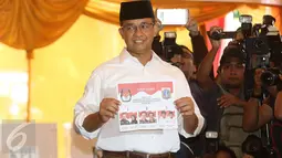 Calon Gubernur DKI Jakarta Anies Baswedan menunjukkan surat suara sebelum mencoblos di TPS 028 Cilandak Barat, Jakarta Selatan, Rabu (15/2). Anies datang bersama istri, Fery Farhati dan anak perempuannya Mutiara Baswedan. (Liputan6.com/Immanuel Antonius)