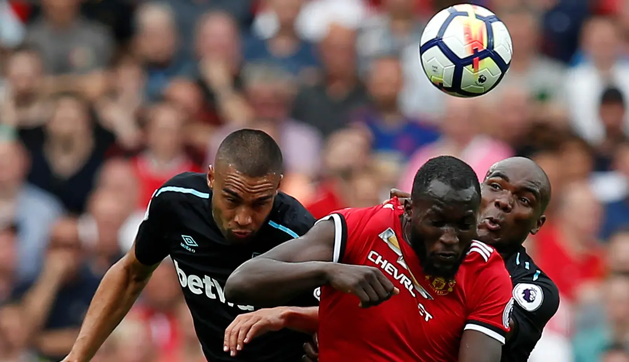 Striker Manchester United, Romelu Lukaku, duel udara dengan pemain West Ham pada laga Premier League di Stadion Old Trafford, Manchester, Minggu (13/8/2017). Manchester United menang 4-0 atas West Ham. (Reuters/Andrew Yates)
