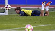 Antoine Griezmann menyundul bola sambil tiduran pada sesi latihan timnas Prancis di Clairefontaine-en-Yvelines dekat Paris, (4/10/2016). Prancis akan melawan Bulgaria pada kualifikasi Piala Dunia 2018. (AFP/Franck Fife)