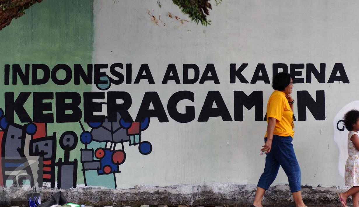 Warga melintas di depan tulisan mural di Lapangan Kebagusan, Jakarta, Rabu (15/2). Jelang menggunakan hak pilihnya pada Pilkada, Ketua Umum PDI-P Megawati Soekarnoputri menggoreskan tinta pada salah satu gambar. (Liputan6.com/Helmi Fithriansyah)