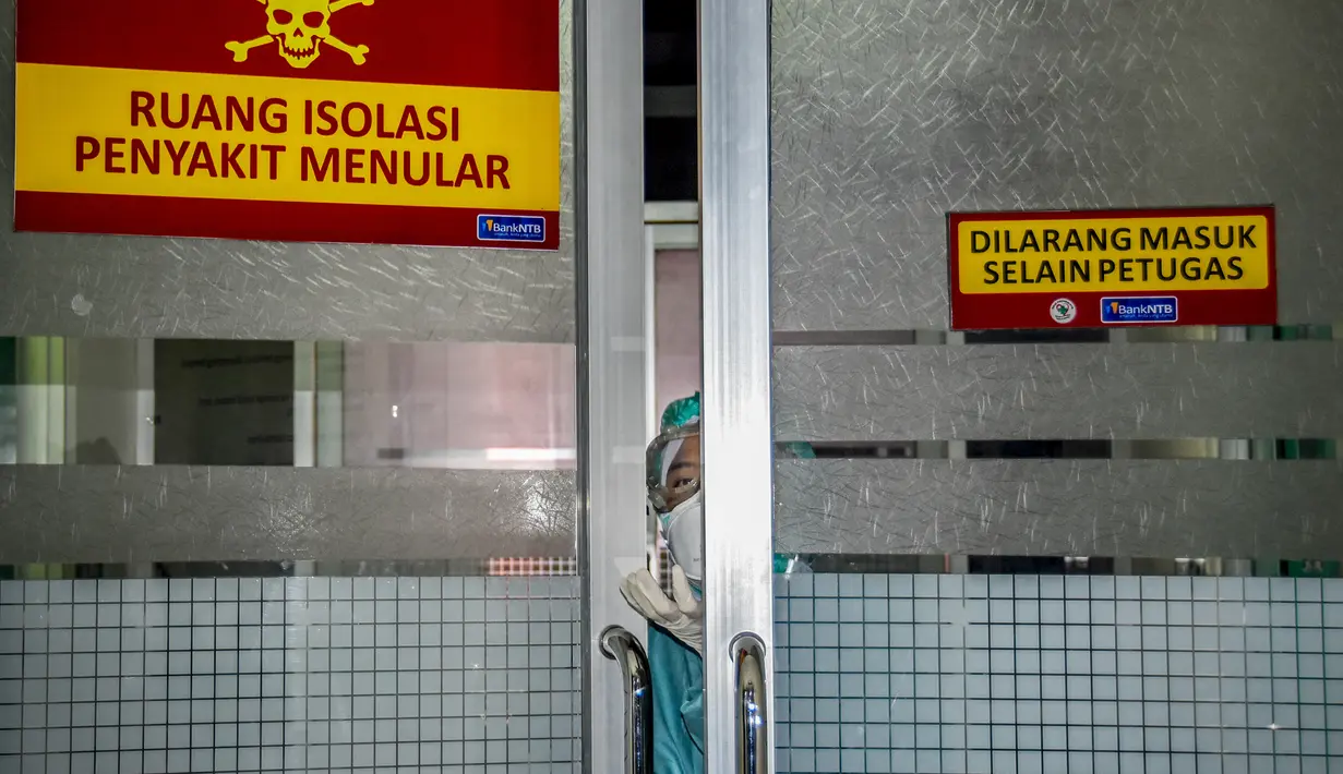 Petugas medis melihat keluar dari ruang isolasi untuk tempat pasien yang menunjukkan gejala wabah virus corona di sebuah rumah sakit umum di Mataram, Nusa Tenggara Barat (28/1/2020). (AFP/Moh El Sasaky)