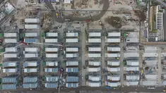 Foto udara menunjukkan lokasi pembangunan fasilitas isolasi sementara untuk menampung pasien Covid-19 yang sedang dibangun di Terminal Kapal Pesiar Kai Tak, Hong Kong (6/4/2022). Bangunan tersebut akan berisi 1.000 tempat tidur dan diharapkan bisa mengurangi beban di rumah sakit umum. (AFP/Yan Zhao)