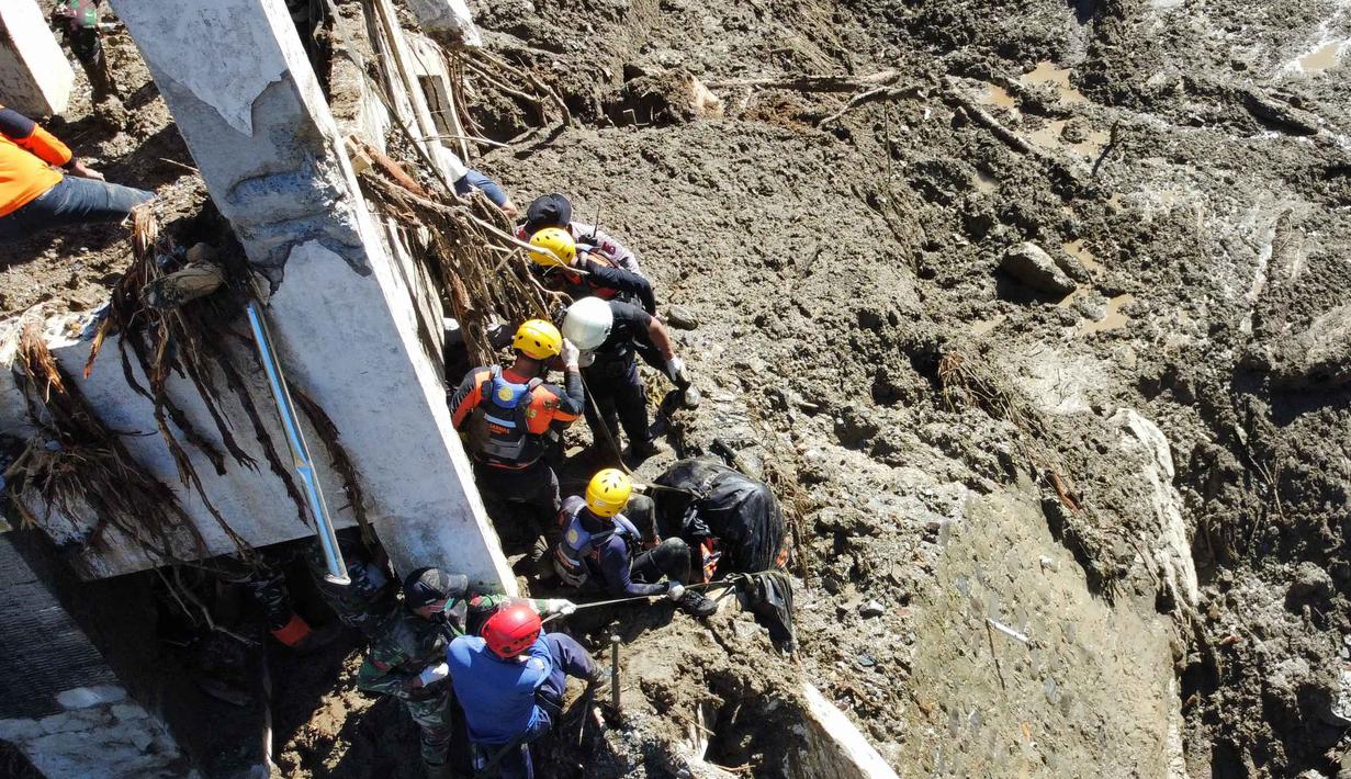 Upaya pencarian dan pertolongan masih berlangsung di berbagai titik terdampak. Tampak dalam foto, tim penyelamat mengevakuasi jenazah korban banjir di Padang Panjang, Sumatera Barat, Senin 1 Desember 2025. (AP Photo/Ali Nayaka)
