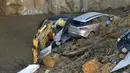 Alat berat dan mobil terlihat ikut ambles ke dalam lubang besar yang menganga di distrik Balduina, Roma, Kamis (15/2). Tidak ada korban jiwa dalam insiden yang terjadi di kawasan permukiman mewah di Roma barat laut itu. (AFP PHOTO / TIZIANA FABI)
