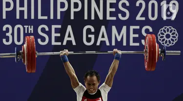 Lifter putra Indonesia, Suratman melakukan angkatan saat SEA Games 2019 cabang angkat besi nomor 55 kg di Stadion Rizal Memorial, Manila, Minggu (1/12/2019). Dirinya meraih perak dengan total angkatan 250 kg. (Bola.com/M Iqbal Ichsan)