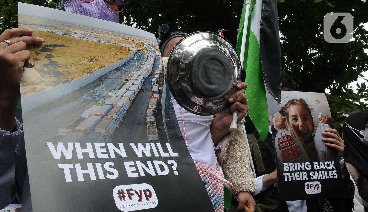 Saat berunjuk rasa, massa membawa beberapa alat masak dan makan seperti panci dan piring yang terbuat dari aluminium sebagai bentuk krisis pangan di Gaza. (merdeka.com/Imam Buhori)