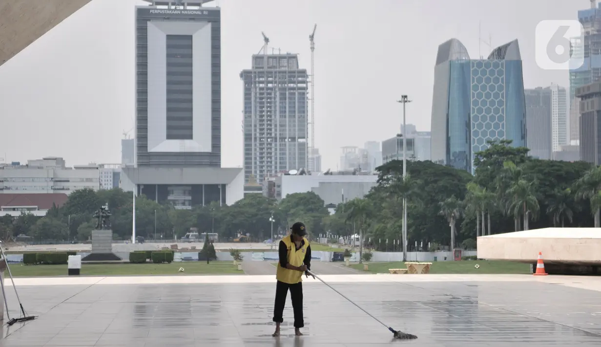 Petugas membersihkan di sekitar Tugu Monas saat ditutup, Jakarta, Minggu (15/3/2020). Gubernur Anies Baswedan menutup tempat wisata di DKI Jakarta seperti Monas, Ragunan, dan museum yang dikelola Pemprov DKI selama dua pekan ke depan guna mencegah penyebaran Covid-19. (merdeka.com/Iqbal S. Nugroho)