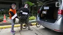 Tersangka Harry Sidabuke (kiri) bersama perantara anggota Komisi II DPR Ihsan Yunus, Agustri Yogasmara mengangkat sepeda Brompton saat rekonstruksi perkara dugaan korupsi pengadaan bantuan sosial penanganan COVID-19 di gedung KPK, Jakarta, Rabu (10/2/2021). (Liputan6.com/Helmi Fithriansyah)