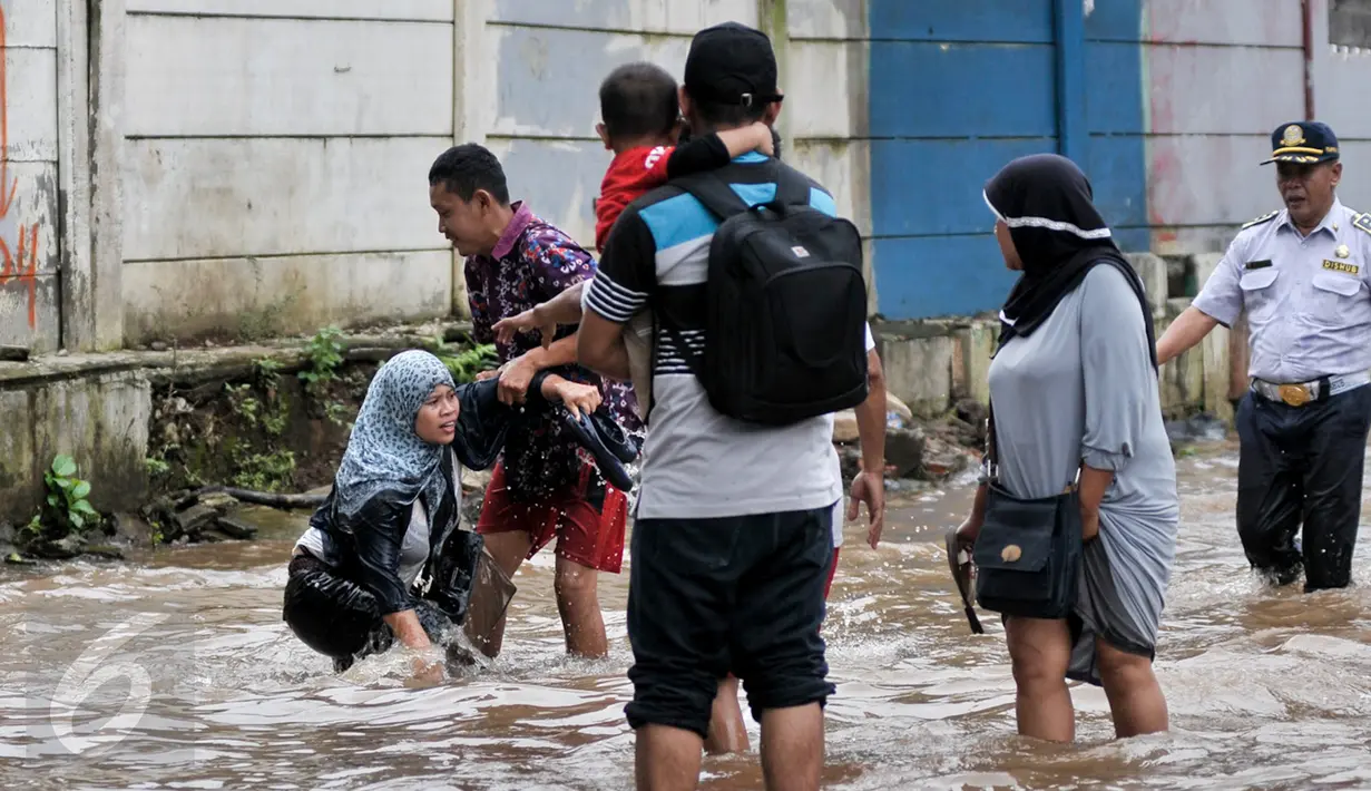 Banjir di kawasan Bukit Duri telah membuat seorang wanita terperosok ke dalam lubang yang tak terlihat karena tertutup oleh genangan air, Jakarta, Selasa (21/2). Tampak seorang lelaki membantu seorang wanita usai terperosok. (Liputan6.com/Yoppy Renato)