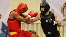 Atlet Wushu Asal China (kiri) menerima pukulan dari Atlet Turki pada Cabang Sanda Kejuaraan Dunia Wushu 2015 di Istora, Senayan, Jakarta,Rabu (18/11/2015). (Bola.com/Nicklas Hanoatubun)