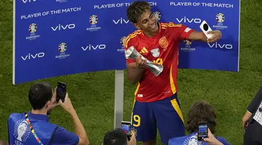 Bintang muda Lamine Yamal menerima trofi pemain terbaik pertandingan pada penghujung laga semifinal EURO 2024 Spanyol vs Prancis di Allianz Arena, Munchen pada Rabu (10/7/2024) dini hari WIB. (AP Photo/Ariel Schalit)