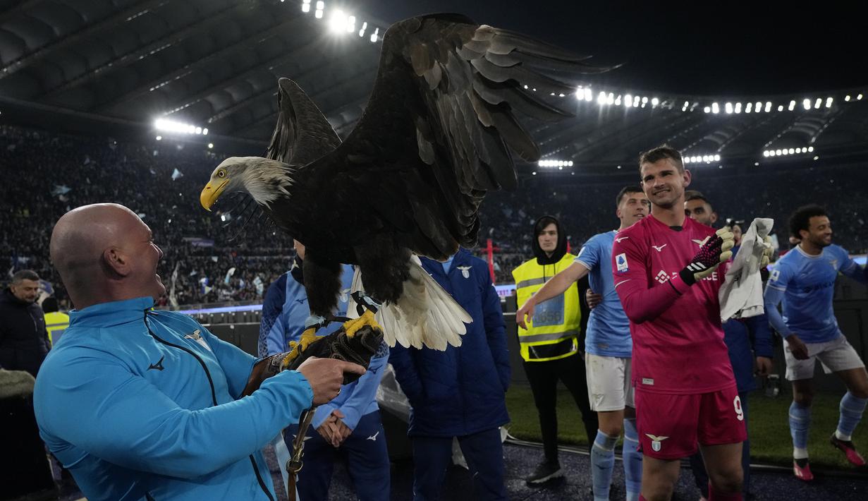 Para pemain Lazio merayakan kemenangan atas Juventus bersama burung elang, Sang Maskot Lazio, setelah berakhirnya laga pekan ke-29 Liga Italia 2022/2023 di Olimpico Stadium, Roma, Minggu (9/4/2023) dini hari WIB. (AP Photo/Alessandra Tarantino)