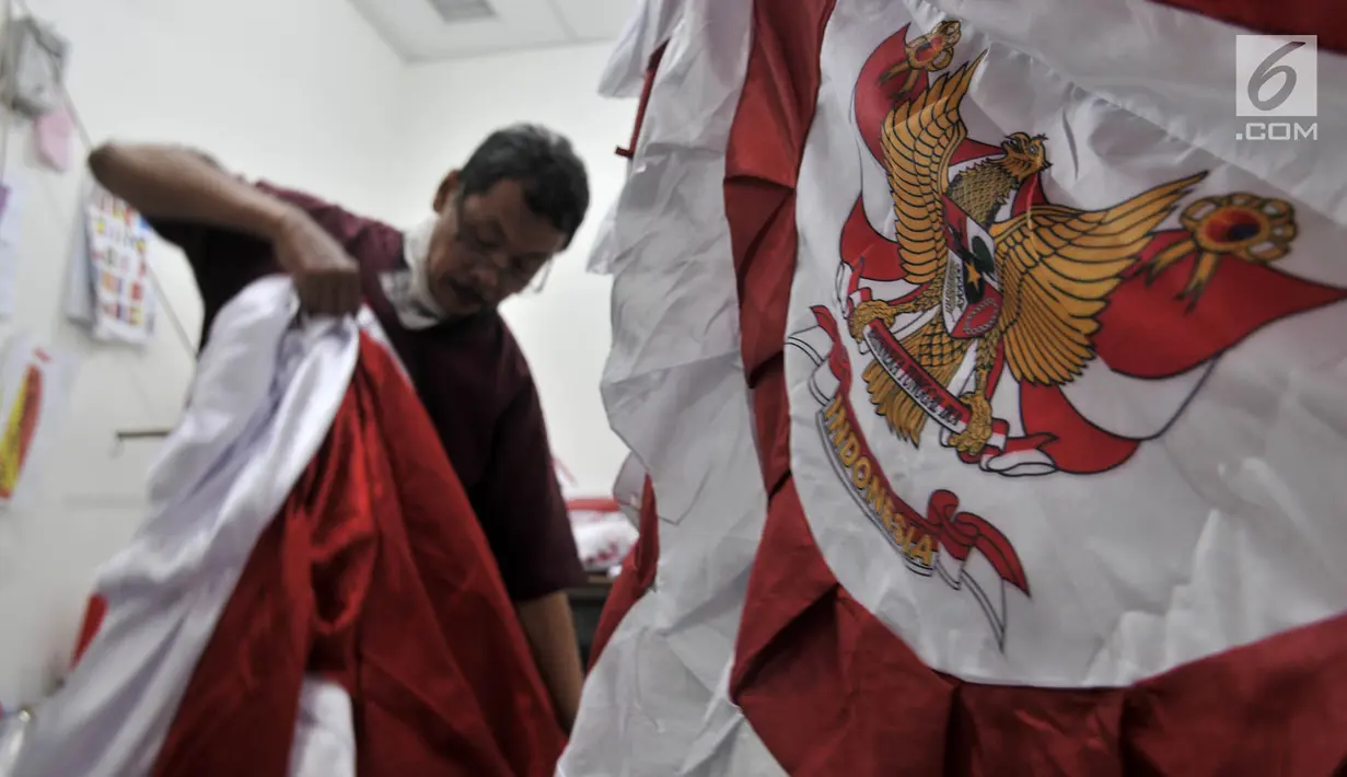 Penjahit merapikan bendera Merah Putih di Pasar Senen, Jakarta, Kamis (2/8). Salah seorang penjahit mengaku pesanan bendera Merah Putih meningkat hingga 50 persen dibandingkan bulan-bulan sebelumnya. (Merdeka.com/Iqbal Nugroho)