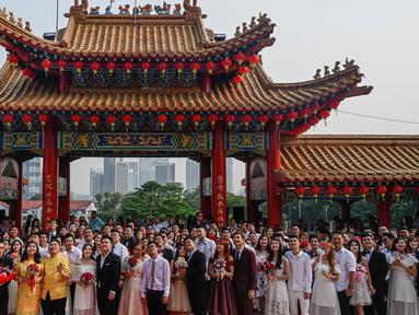 Pasangan pengantin baru keturunan Tionghoa  berfoto bersama seusai acara pernikahan massal di Kuil Thean Hou, Kuala Lumpur, Senin (9/9/2019). Upacara pernikahan massal diadakan untuk 99 pasangan pada hari kesembilan bulan kesembilan yang dianggap sebagai tanggal keberuntungan. (Mohd RASFAN / AFP)