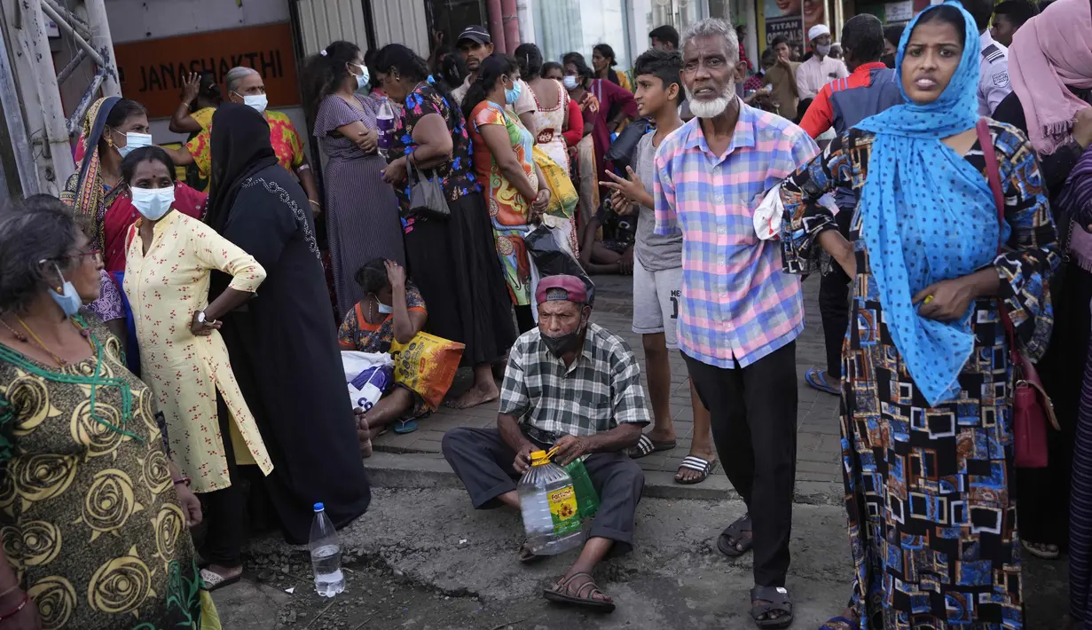 Orang-orang menunggu di dekat pompa bensin yang kosong berharap untuk membeli minyak tanah untuk memasak di Kolombo, Sri Lanka, Kamis (26/5/2022). Ada kekurangan banyak barang kebutuhan , mulai dari makanan, gas untuk memasak, obat-obatan dan bahan bakar hingga kertas toilet dan korek api. (AP Photo/Eranga Jayawardena)