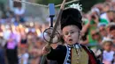 Seorang anak berlari sambil memasukan tombak kayu ke lubang sasaran selama turnamen tradisional Alka di desa Vuckovici, Kroasia, Minggu (23/8/2015).  Alka adalah turnamen yang diselenggarakan setiap bulan Agustus sejak 1955. (REUTERS/Antonio Bronic)