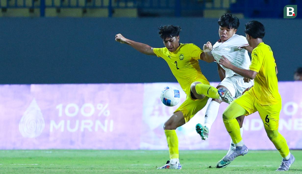 Pemain Timnas Indonesia U-17, Dava Yunna Adi Putra, berusaha melewati pemain Malaysia pada laga kedua Grup A Piala AFF U-17 2026 di Stadion Gelora Joko Samudro, Gresik, Jawa Timur, Kamis (16/4/2026) malam. (Bola.com/M Iqbal Ichsan)