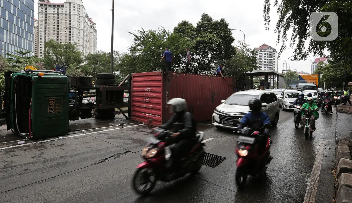 Petugas melakukan evakuasi Kontainer yang terguling di Jalan S Parman, Jakarta Barat, Senin (4/5/2020). Tidak ada korban jiwa dalam kecelakaan tersebut, namun kecelakaan tersebut membuat lalin dijalan itu terimbas kemacetan yang cukup panjang. (Liputan6.com/Johan Tallo)