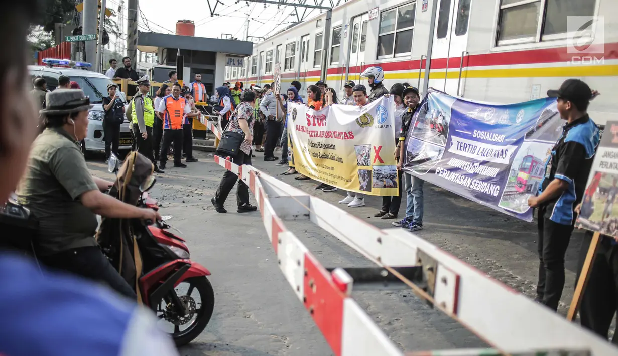 Petugas PT KAI Daop I menggelar sosialisasi tertib berlalu lintas di pintu perlintasan sebidang kawasan Bukit Duri, Jakarta, Selasa (17/9/2019). Sosialisasi dilakukan karena banyaknya kecelakaan akibat ketidakdisiplinan pengendara. (Liputan6.com/Faizal Fanani)