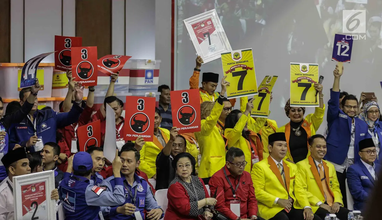 Pendukung peserta partai politik PDIP, Demokrat, Gerindra dan Berkarya menunjukkan nomor parpol sambil yel-yel usai pengambilan nomor urut peserta pemilu 2019 di KPU, Jakarta, Minggu (18/2). (Liputan6.com/Faizal Fanani)