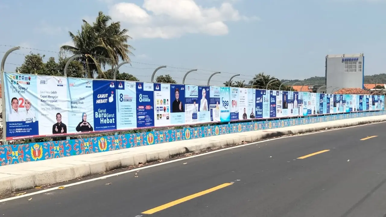 Bentangan spanduk raksasa sepanjang 75 meter dengan lebar 1,5 meter paslon SANTRI di jalan Pameungpeuk, Garut Selatan, menjadi viral lantaran ukurannya yang tidak biasa, selama kampanye terbuka Pilkada Garut 2024. (Liputan6.com/Jayadi Supriadin)