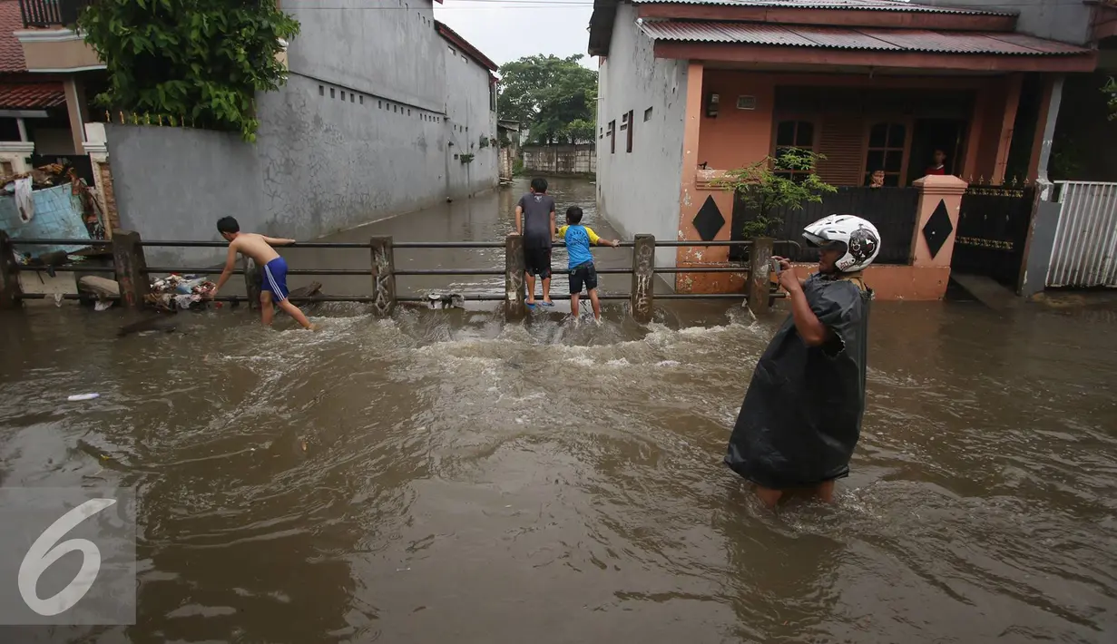 Warga melintasi banjir yang menggenangi Jalan Ketapang di kawasan Pasar Minggu, Jakarta, Selasa (4/10). Banjir yang berasal dari luapan Kali Anur tersebut menyebabkan Jalan Ketapang tidak bisa dilewati kendaraan. (Liputan6.com/Immanuel Antonius)