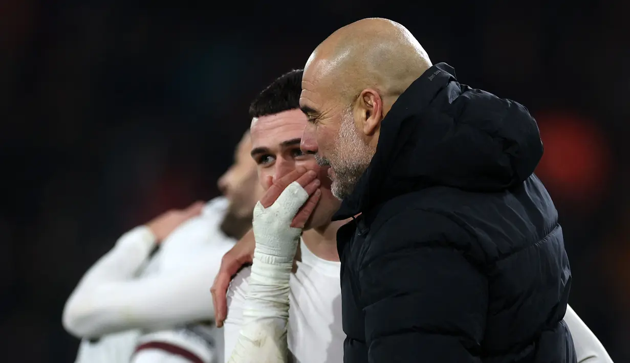 Pemain Manchester City, Phil Foden (kiri) berbincang dengan pelatih Pep Guardiola setelah laga lanjutan Liga Inggris 2023/2024 melawan Bournemouth yang berlangsung di Vitality Stadium, Bournemouth, Inggris, Minggu (25/02/2024) dini hari WIB. (AFP/Adrian Dennis)