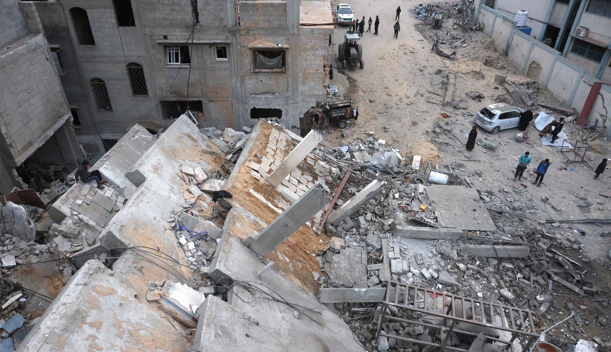 Serangan Israel ini diluncurkan meski perjanjian gencatan senjata antara kedua pihak berseteru masih berlaku. Tampak dalam foto, warga Palestina yang mengungsi memeriksa kerusakan setelah pesawat Israel menargetkan sebuah rumah berlantai lima tadi malam, di Khan Yunis, Jalur Gaza selatan, pada Kamis 6 Februari 2026. (Bashar Taleb/AFP)