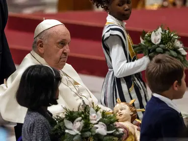 Paus Fransiskus memegang patung Bayi Yesus saat memimpin Misa Malam Natal di Basilika Santo Petrus, Vatikan, Minggu (24/12/2023). (AP Photo/Gregorio Borgia)