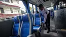 Petugas mengecek kondisi kursi dalam bus Transjabodetabek Premium milik Perum PPD saat menunggu calon penumpang di Tamini Square, Jakarta, Kamis (14/12). (Liputan6.com/Faizal Fanani)